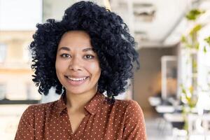 retrato de un smilling y seguro de sí mismo afroamericano mujer de negocios, propietario de un restaurante, bar y mirando a el cámara. foto