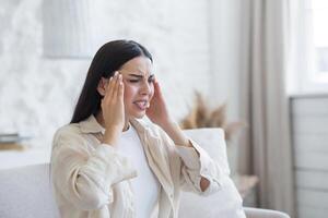 A woman suffering from depression, mental disorders. He is sitting at home feeling a strong headache photo