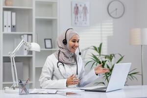 Cheerful healthcare professional in a modern clinic office, interacting with patients online, telemedicine concept with Middle Eastern influence. photo