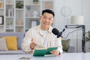 A focused individual conducting a virtual book reading session with a microphone and a book in a home environment. photo