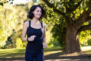 un sonriente mujer disfruta un soleado día en el parque mientras correr, personificando salud y un activo estilo de vida. foto