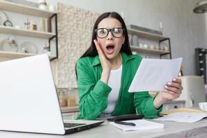 Portrait of a shocked woman at home, received bad news a letter from the bank photo