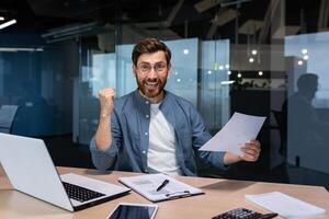 Portrait happy businessman financier, mature man with breed looking at camera and smiling, holding report with good achievement results and financial indicators celebrating victory, triumph gesture photo