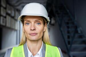 Professional woman engineer with serious expression wearing safety gear at a construction site. photo