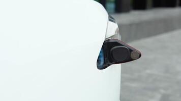 Electric car on a charging station with back and light plug detail, electric mobility video