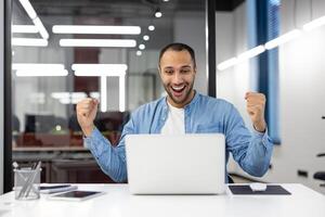 un jubiloso oficina trabajador celebra un exitoso momento, mostrando un positivo reacción con un puño bomba en un brillante oficina ajuste. foto