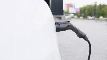 Puissance la fourniture pour électrique voiture mise en charge. électrique voiture mise en charge gare. proche en haut de le Puissance la fourniture branché dans un électrique voiture étant accusé video