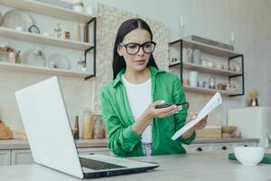 preocupado mujer estudiando en línea con ordenador portátil cocina hermosa estudiante no comprensión información foto