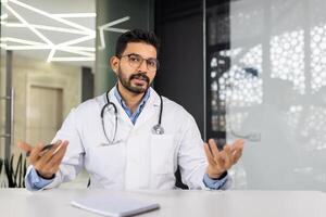 un médico es sentado a un escritorio con un portapapeles y un bolígrafo foto