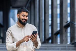 Smiling man using smartphone in urban setting, happy and connected photo