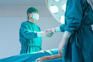 Medical team performing a surgical operation in operating room, Concentrated surgical team operating a patient photo