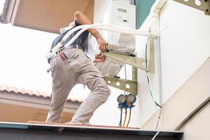 Repairman service for repair and maintenance of air conditioners, Technician man install new air conditioner photo