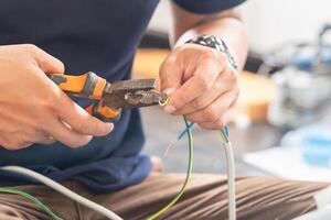 Technician man connecting electric wires with pliers to install new air conditioning, repair service, and install new air conditioner concepts photo