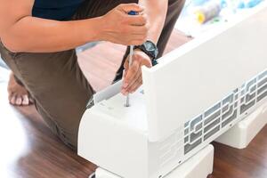 Technician using a screwdriver to fix modern air conditioners, repair and service, maintenance and install a new air conditioner photo