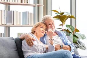 Senior couple in the living room, Elderly man and a woman relaxing on a cozy sofa at home, Happy family concepts photo