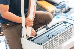 Technician man install new air conditioner, Repairman service for repair and maintenance of air conditioners photo