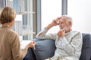 Elderly man consulting senior woman on the cozy sofa at home, Elderly medical health care concepts, Senior couple in living room photo