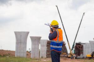 Engineer man checking project at building site, Foreman worker in hardhats on construction site photo