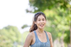 Asian sportswoman cools down by pouring fresh water, female fitness pouring water over her perfect body photo