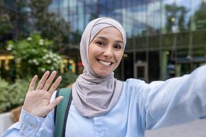 A respectful image showing a Muslim woman in a hijab, holding up her hand to decline photos in an urban setting, embodying privacy and consent.