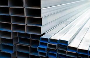 Industrial warehouse stock of rectangular metal pipes for building and construction supplies. Stack of steel pipes. Iron materials for construction and infrastructure projects. Steel tubing storage. photo