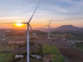 Wind farm field and sunset sky. Wind power. Sustainable, renewable energy. Wind turbines generate electricity. Sustainable development. Green technology for energy sustainability. Eco-friendly energy. photo