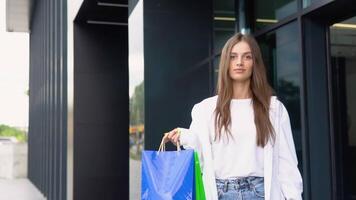 jong mooi vrouw wandelen in de buurt de op te slaan met een pakket van voedsel of kleren video