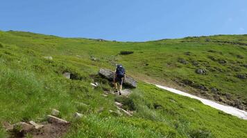 Mens wandelingen langs de bergen naar de top. reizen concept actief mensen Aan de manier naar zege Actie vooruit dichtbij omhoog. toerist in laarzen gaan langs de steen weg Aan de achtergrond een mooi landschap video