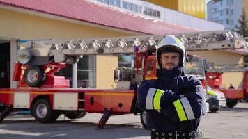 ritratto di coraggioso vigile del fuoco con casco vicino fuoco motore. pompiere ritratto su dovere video