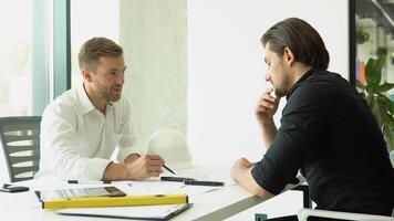 Engineer and architect reviewing office blueprints and technical drawings video