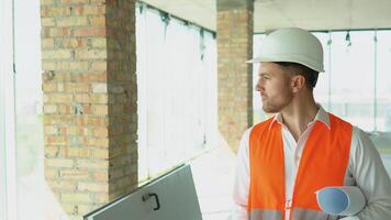 ingenieur ontwikkelaar in helm inspecteren gebouw. architect zijn wandelen langs de gebouw in vooruitgang video