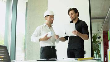 Engineer and architect reviewing office blueprints and technical drawings video