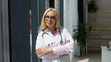 Female physician posing in hospital office. Positive general practitioner close up face portrait video