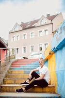 A man is sitting on a set of stairs in front of a building photo