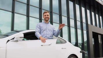 hombre cargando eléctrico coche cerca el negocio centrar video