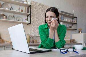 Online consultation with a family psychologist, a young beautiful woman in the kitchen photo