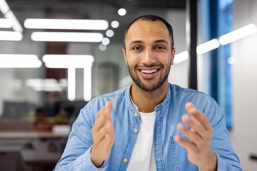 alegre indio hombre a hogar en un vivo habitación, comprometido en un negocio llamar, comunicado con colegas o clientela. foto