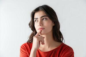 young beautiful woman in a stylish dark red shirt, touching her chin with her hand while raising her index finger up photo