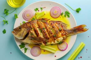 tempting grilled carp on a clean white plate, The fish is cloaked in a golden-yellow sauce, with slices of red onions photo