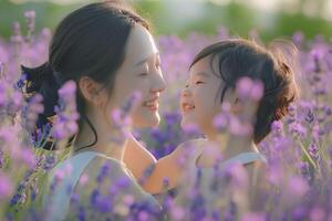 asiático mujer y su niño sonrisa a cada otro con puro alegría en el lavanda flor campo foto