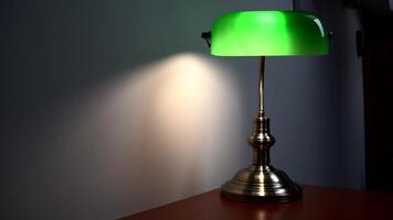 een elegant groen lezing lamp staat Aan een bruin bureau. luxueus appartement decor. video