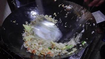 Cocinando tradicional indonesio frito arroz utilizando un grande wok Disparo con Mano movimienot. video