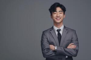 young korean man wearing gray suits smile with their arms folded across their chests photo