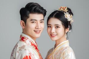 young couple wearing traditional Chinese attire, smiling softly and elegantly, looking towards the camera photo