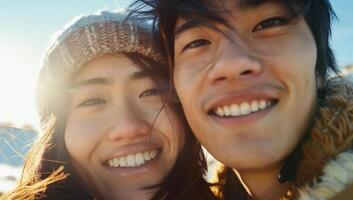 Portrait of a happy young asian couple looking at camera in the park photo