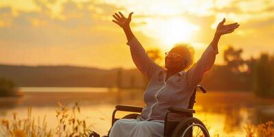 Elderly woman in a wheelchair at sunset. Retirement concept. photo