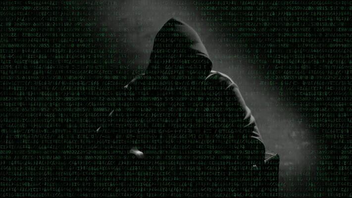 Anonymous man in a hood interview footage. Mysterious man sitting on a  chair and talking. Anonymous hacker interview with no visible face,  computer hacker conceptual background