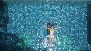 caucásico mujer nadando en el espalda en el piscina en lento movimiento. video