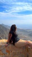 Happy asian woman tourist raise hands enjoys breathing fresh air high in cloudy mountains at cold weather. Young hiker at amazing hazy background of mountain landscape standing back. Active sport. video