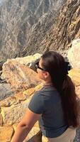 Happy asian woman tourist raise hands enjoys breathing fresh air high in cloudy mountains at cold weather. Young hiker at amazing hazy background of mountain landscape standing back. Active sport. video